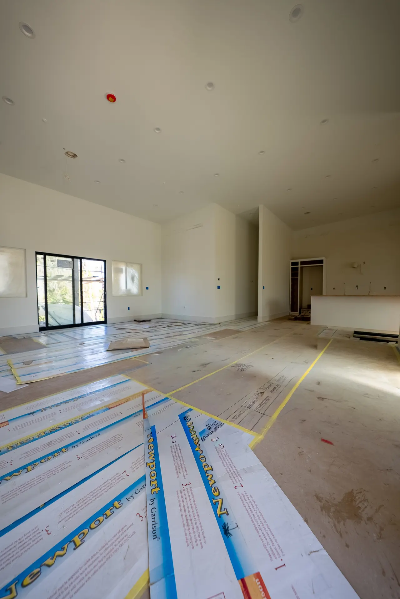 Open-concept living space with a sliding glass door to the backyard and wood flooring, opening toward the kitchen