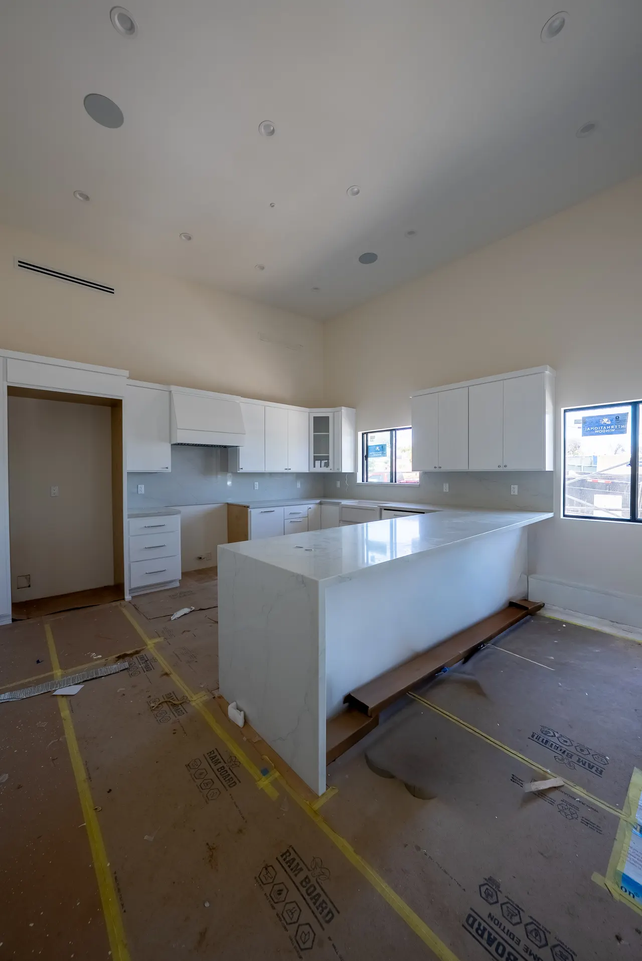 Close view of the white kitchen island and cabinetry with an open drawer and hardware detail