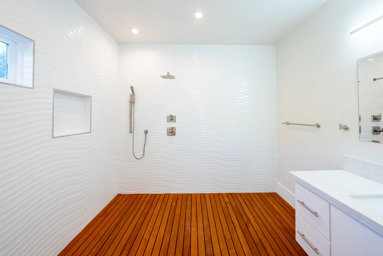 Walk-in shower with a teak floor and full-height tile