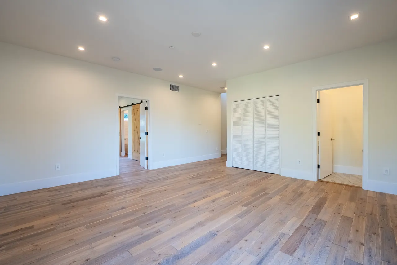 Bedroom with sliding barn doors and a walk-in closet