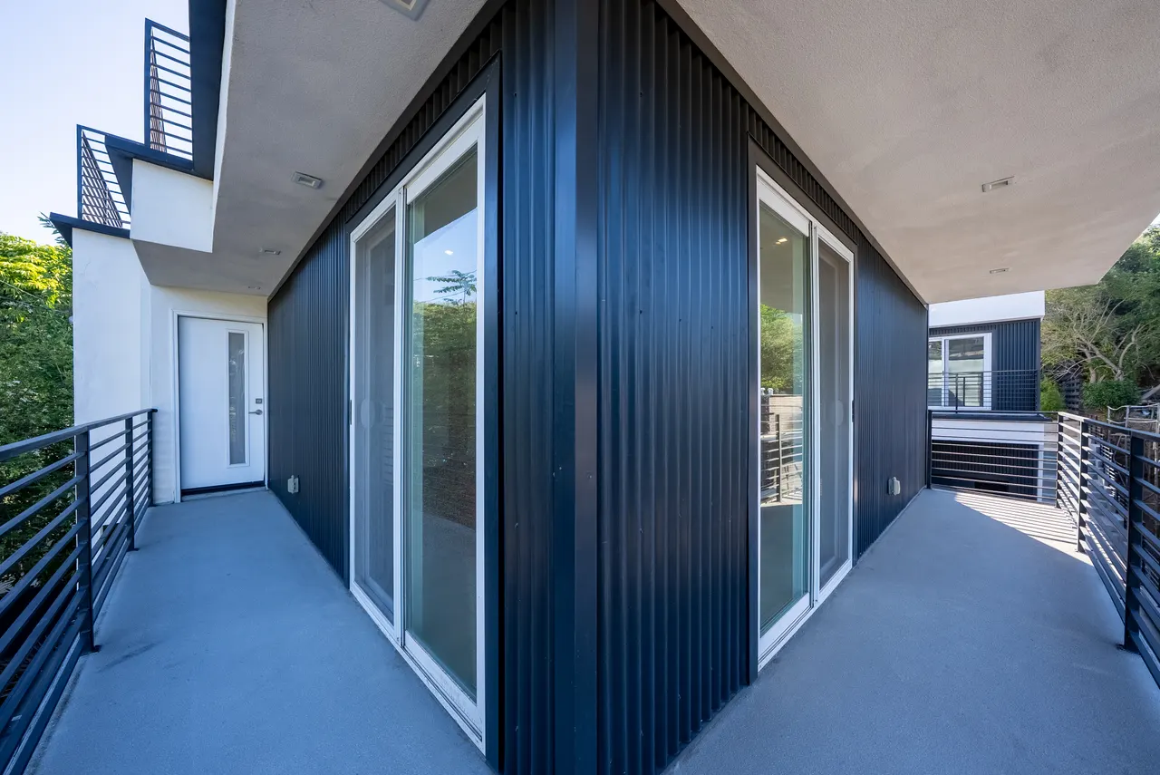 Dark-clad exterior with corner sliding glass doors opening onto the deck