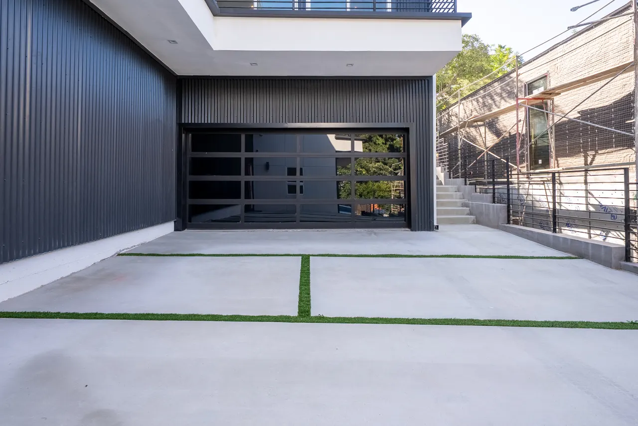 Modern glass garage door and concrete driveway