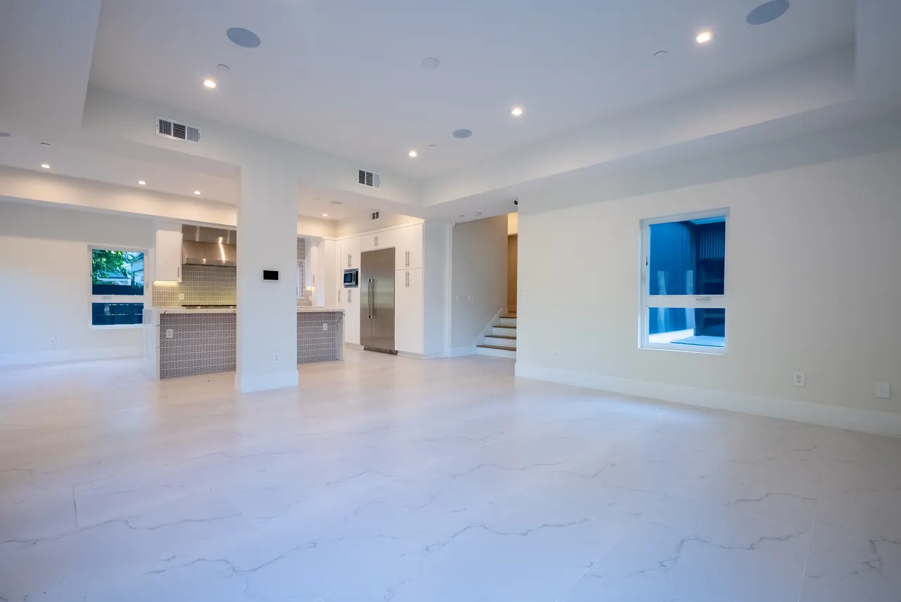 Open great room with marble floors flowing into the kitchen