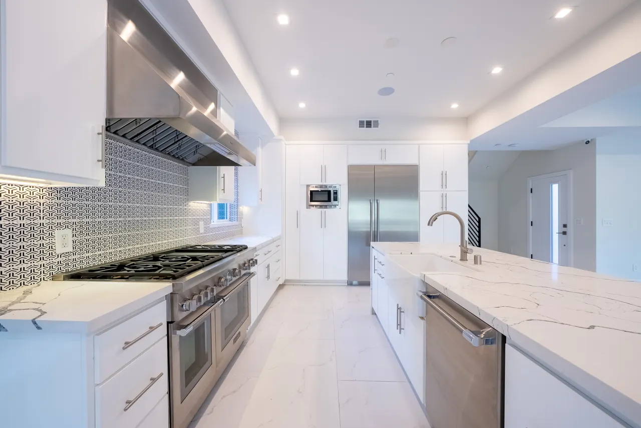 Kitchen with vent hood, range, and marble island seating